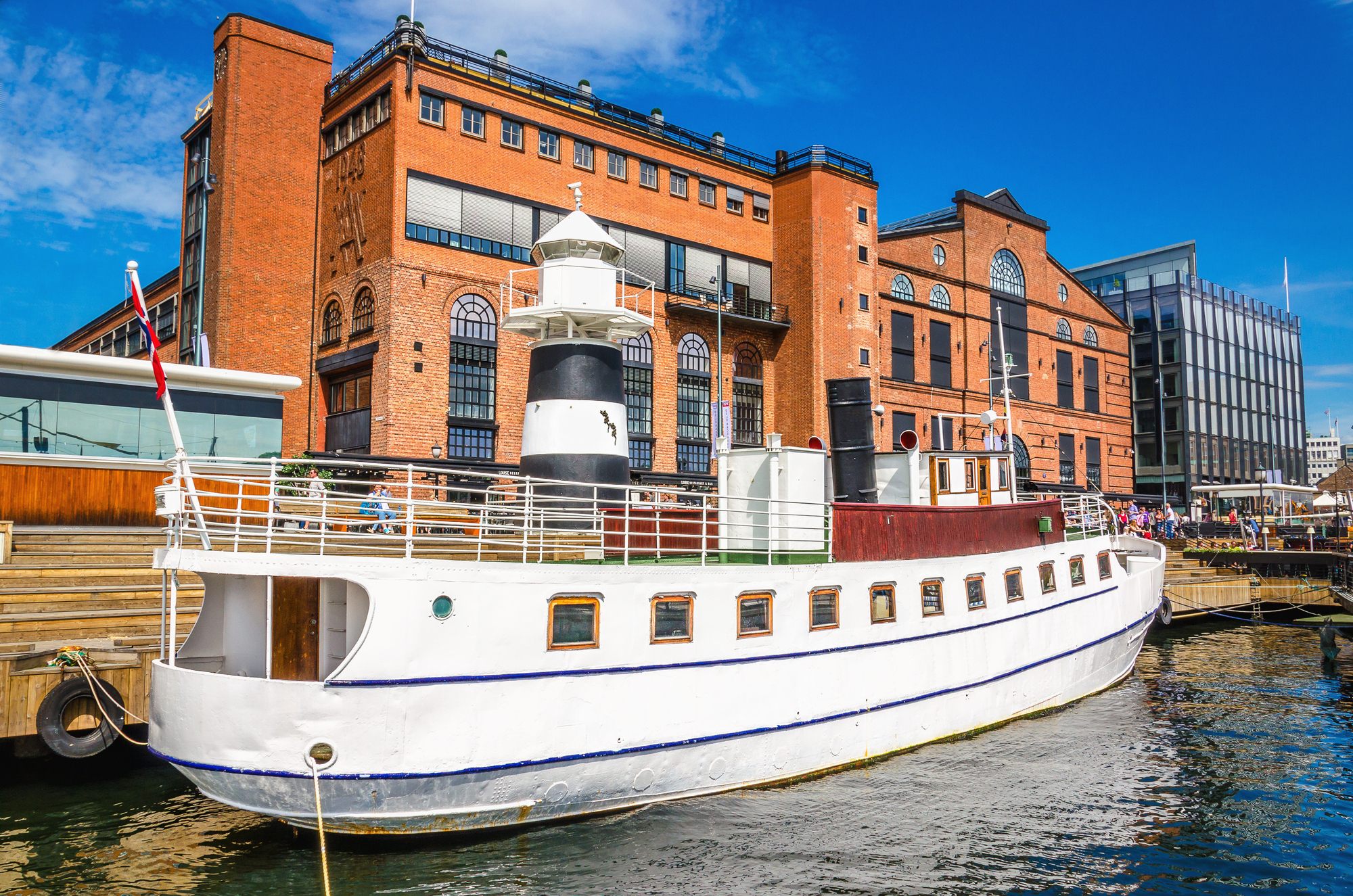 Aker Brygge a Oslo con uno yacht bianco nel porto
