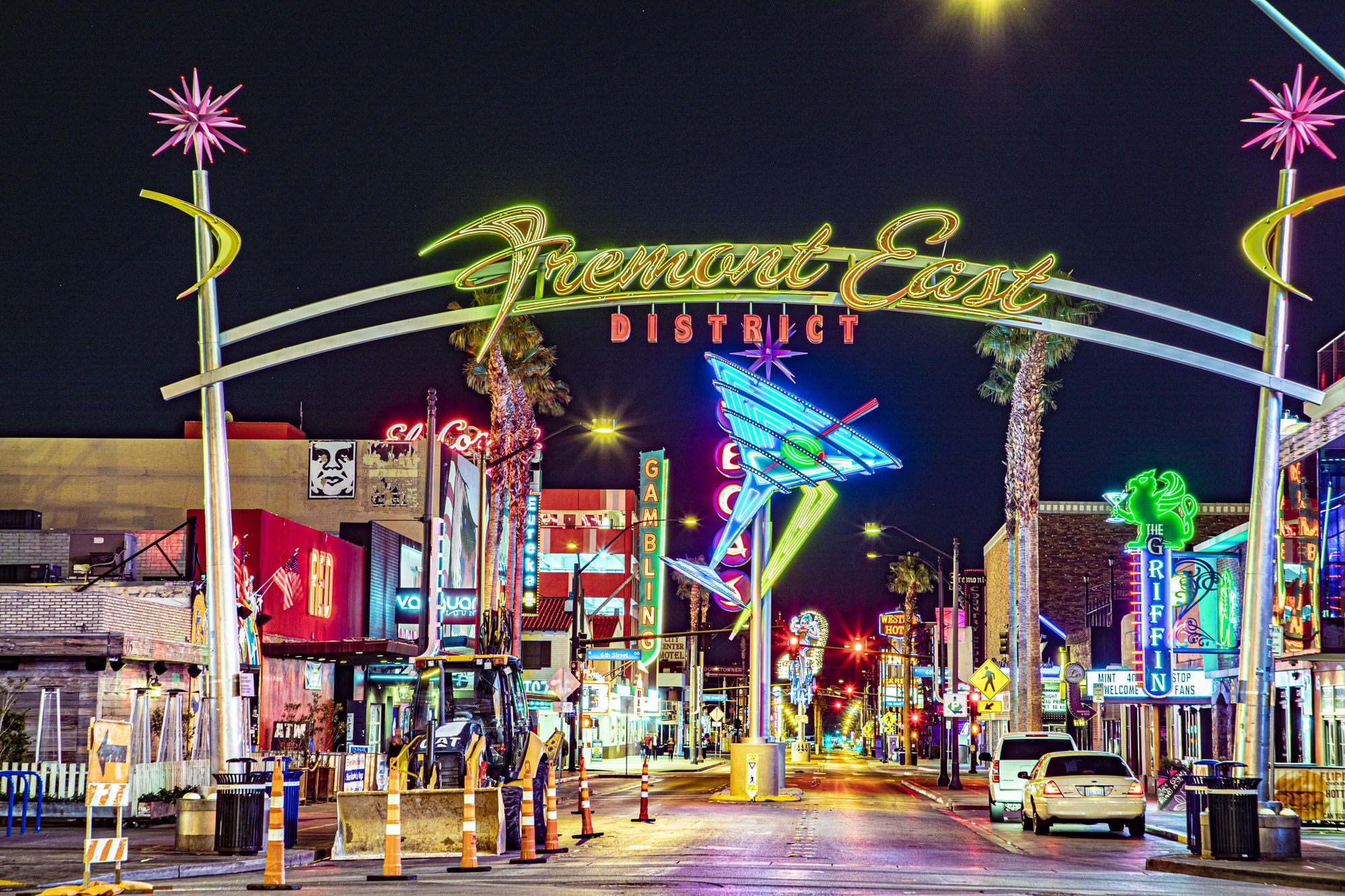 L'arco illuminato del Fremont East District sopra una strada con insegne al neon di notte