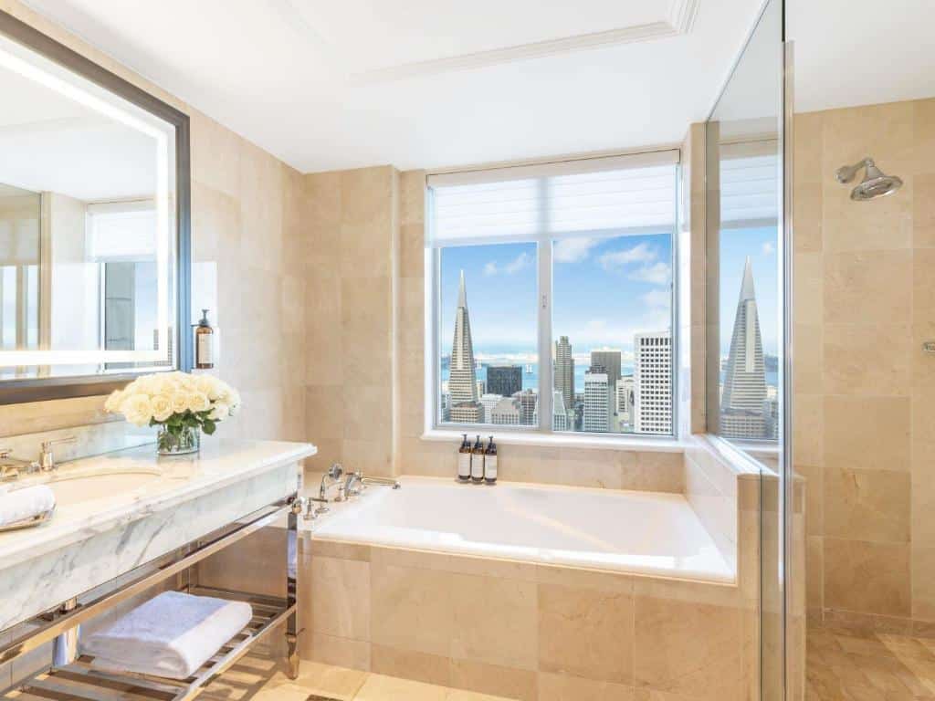 Bagno con vasca e finestra affacciata sulla città al Fairmont San Francisco