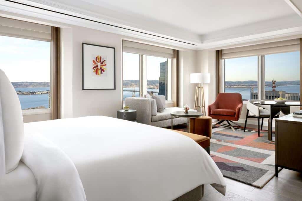 Camera da letto e zona soggiorno con grandi finestre al Four Seasons Hotel San Francisco at Embarcadero