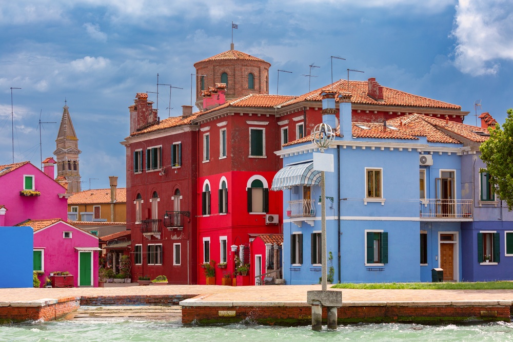 Case colorate lungo un canale a Burano con il campanile sullo sfondo