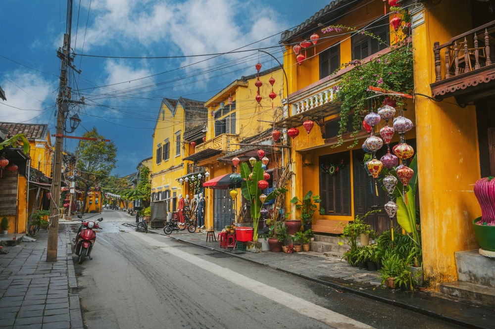 Case gialle e lanterne di carta in una via del centro storico di Hoi An