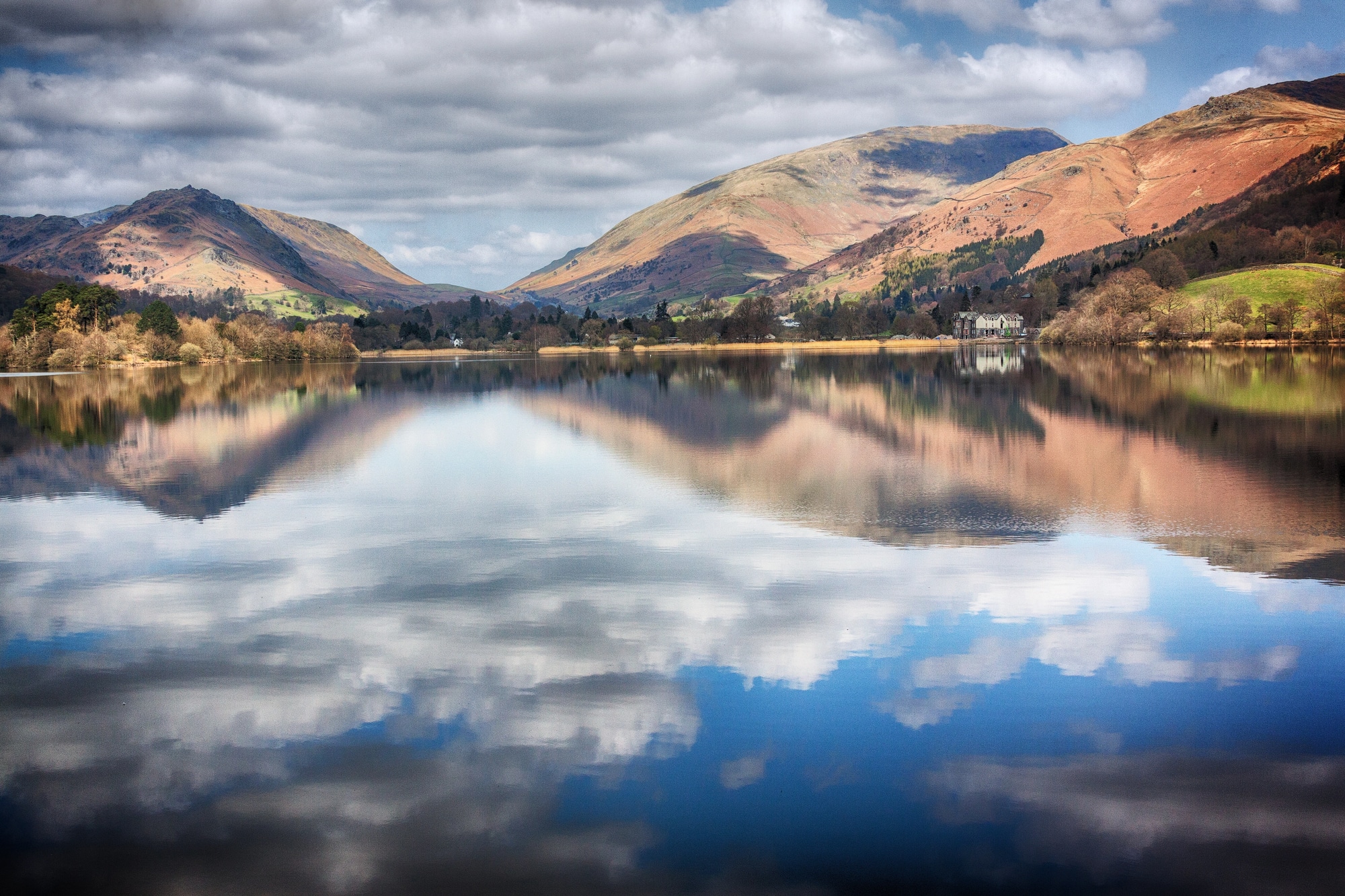 Colline autunnali e nuvole riflesse nell'acqua immobile del lago di Grasmere