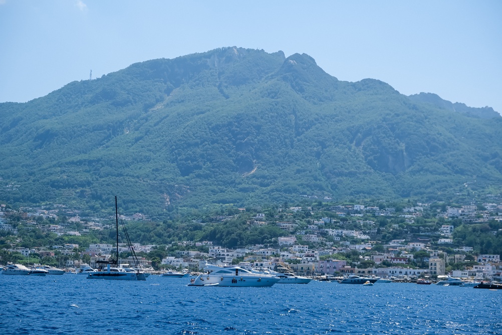 Il Monte Epomeo e un paese di mare a Ischia con le barche ormeggiate in primo piano