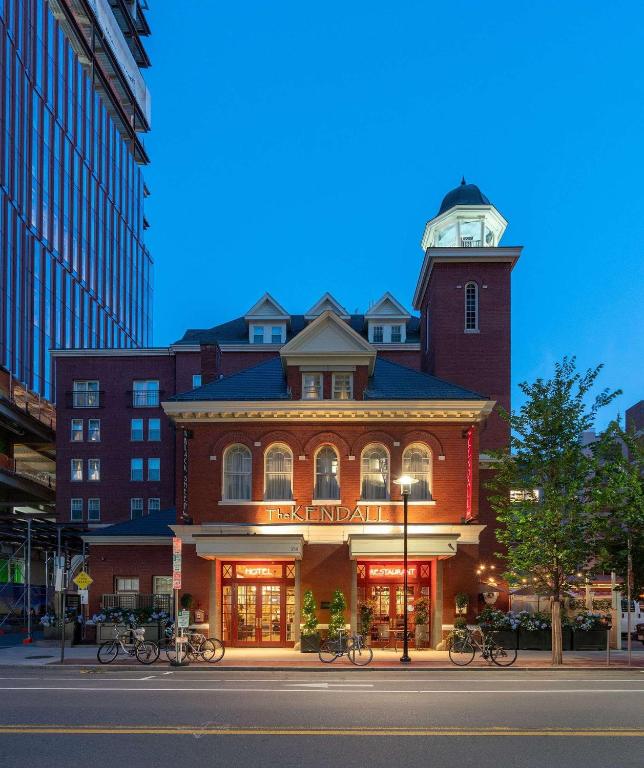 Edificio storico in mattoni rossi e ingresso illuminato di The Kendall Hotel al crepuscolo