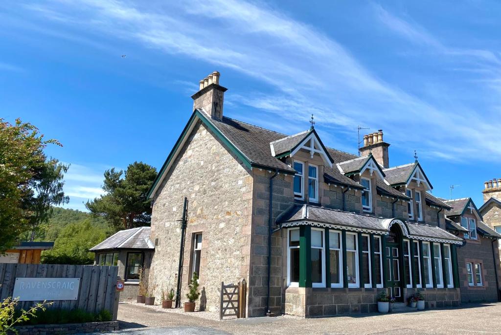 Facciata in pietra della Ravenscraig Guest House sotto un cielo azzurro ad Aviemore