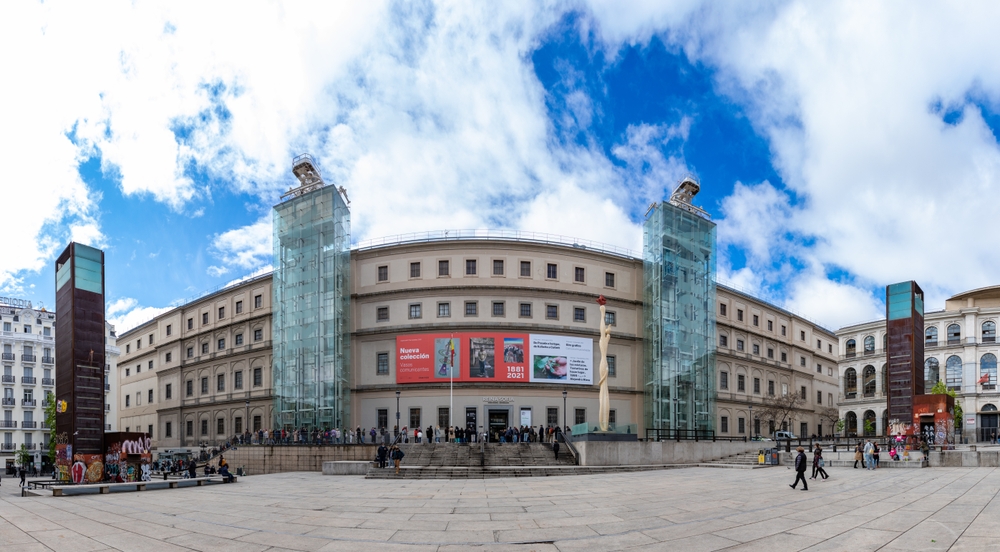 La facciata principale del Museo Reina Sofía a Madrid con visitatori in coda all'ingresso