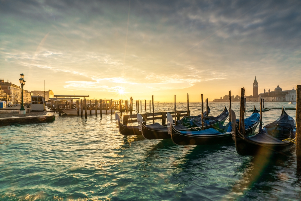 Gondole ormeggiate lungo la riva a Venezia al tramonto