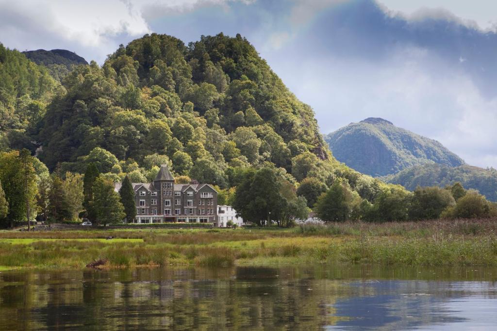 Il Lodore Falls Hotel riflesso nell'acqua del Derwentwater con il bosco alle spalle