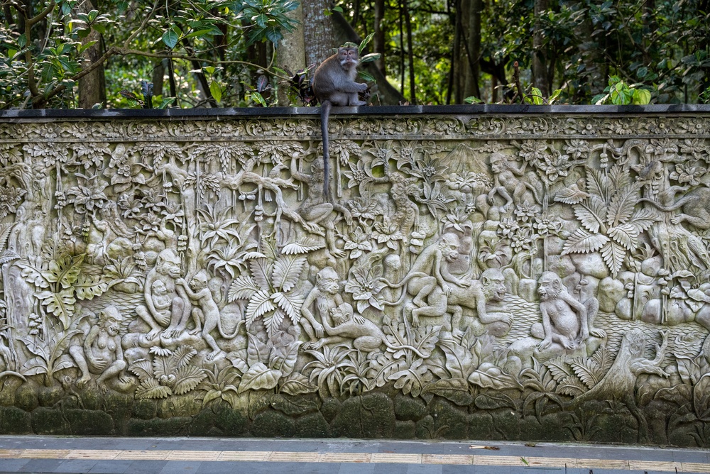 Macaco su un bassorilievo in pietra nella Monkey Forest di Ubud