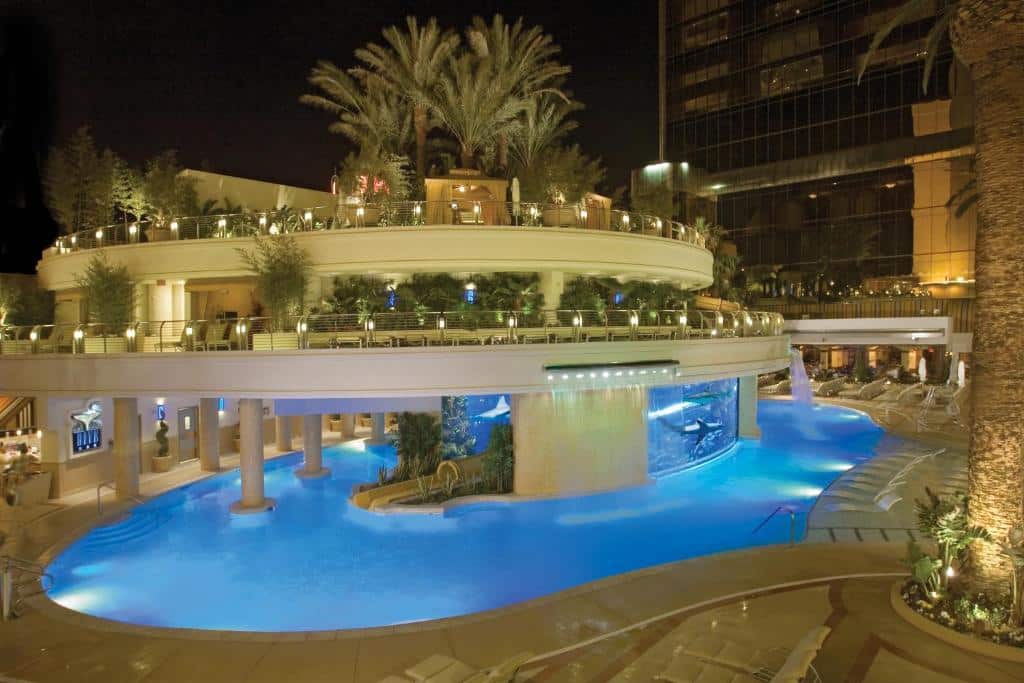La piscina del Golden Nugget illuminata di blu di notte, con palme e terrazze