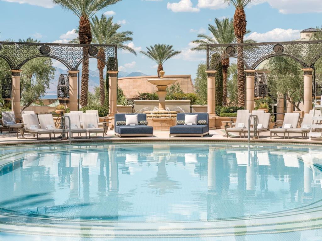 Piscina turchese con palme e lettini al The Palazzo at The Venetian