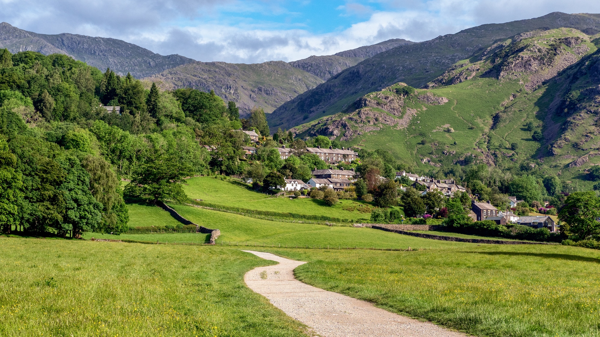 Sentiero in un prato verso il villaggio di Coniston con colline sullo sfondo