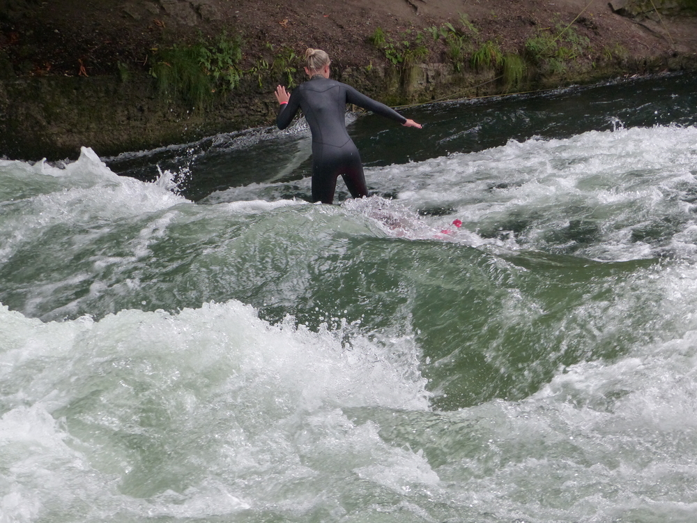 Un surfista sull'onda dell'Eisbach vicino all'Englischer Garten a Monaco di Baviera