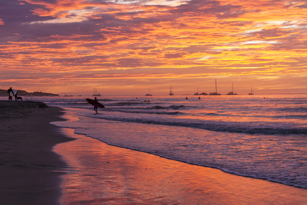 Surfista sulla spiaggia di Tamarindo, nel Guanacaste, al tramonto
