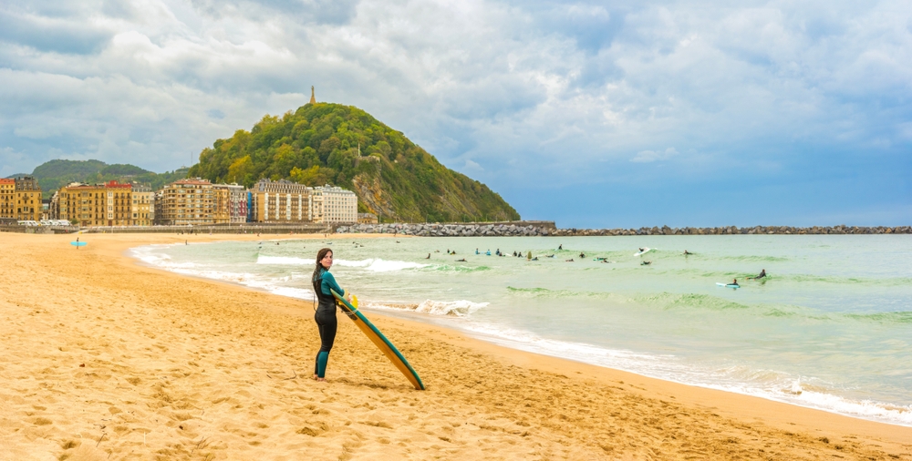 Surfista sulla spiaggia di Zurriola a Gros, San Sebastián
