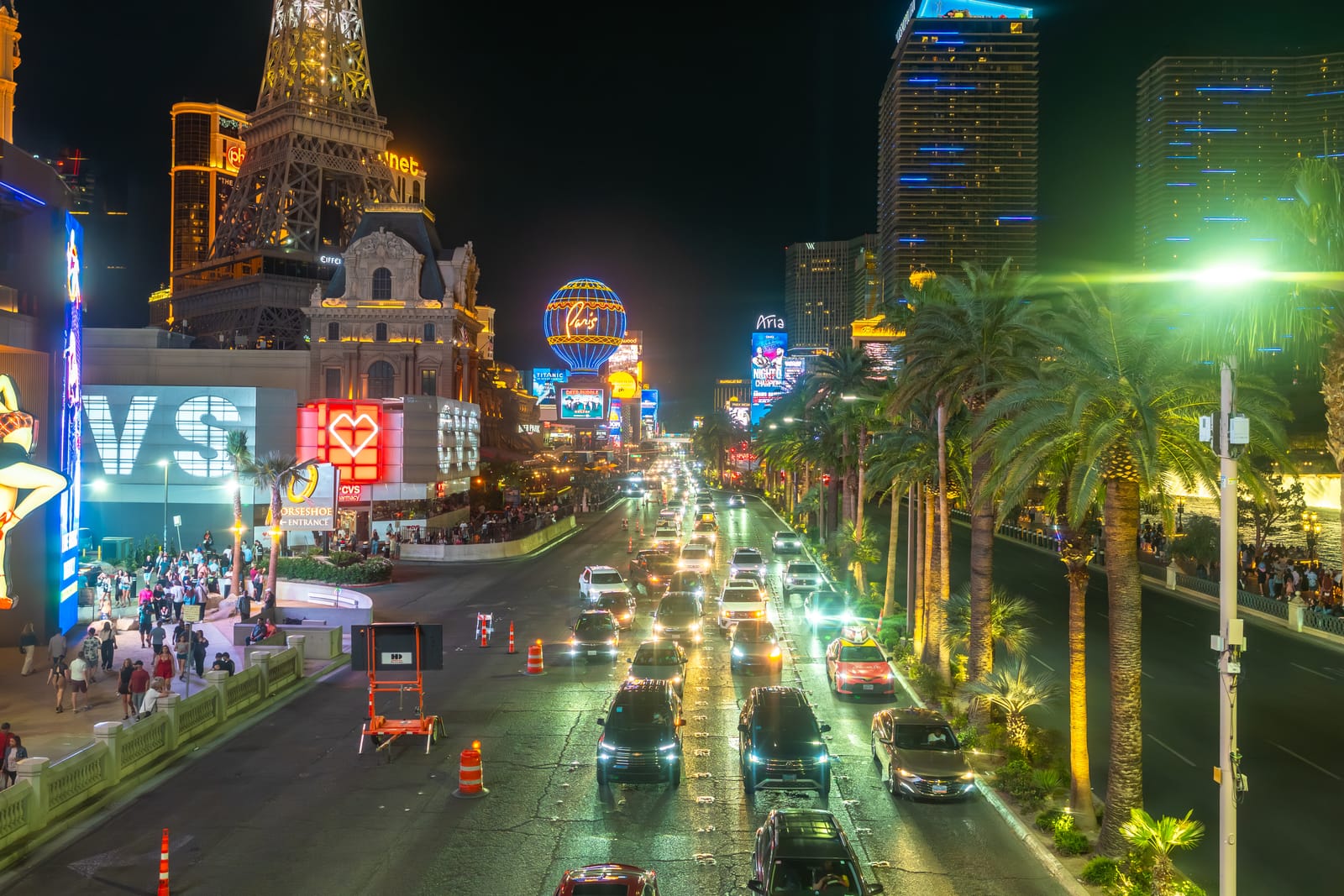 Traffico, palme e hotel illuminati lungo la Strip di Las Vegas di notte