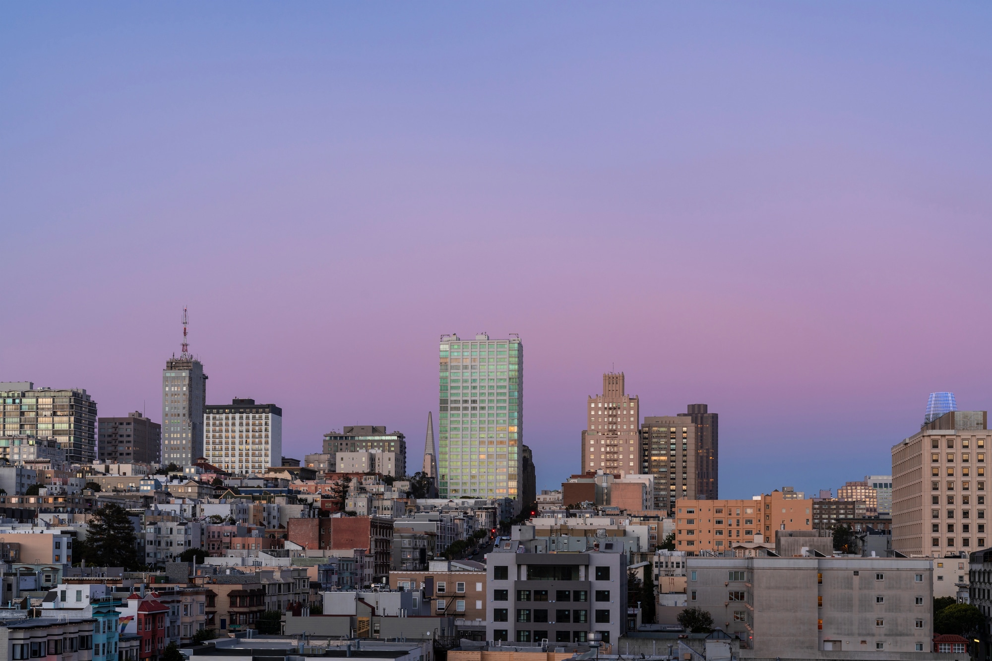 Vista sugli edifici e le colline di San Francisco sotto un cielo serale rosa